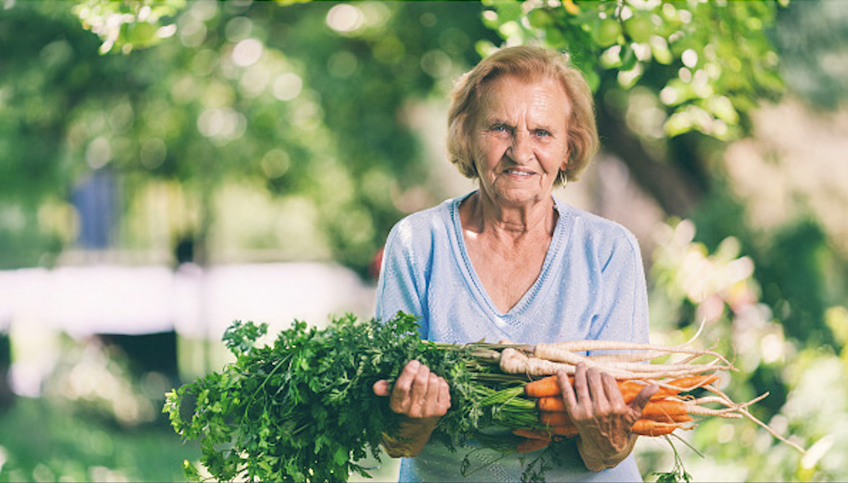 Smiling woman holding carrots