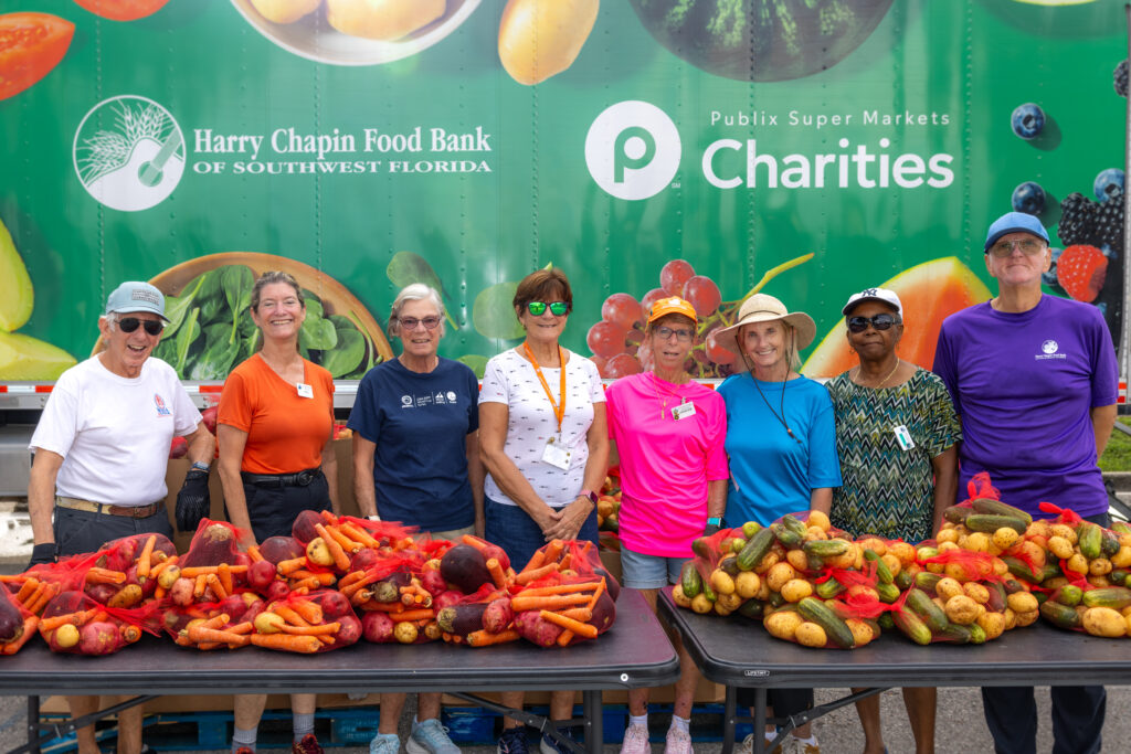 A group of volunteers pose together at a mobile food distribution