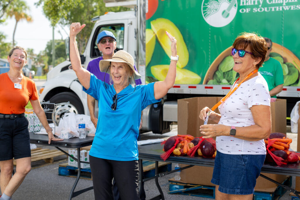 Volunteers cheer together at a Harry Chapin Food Bank mobile food distribution